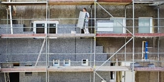 Eingerüstete Fassade eines Hauses an welche Aussendämmung angebracht wird